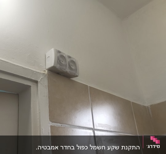 שקע חשמלי מותקן על קיר אריחים